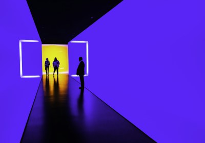 three person standing near wall inside building