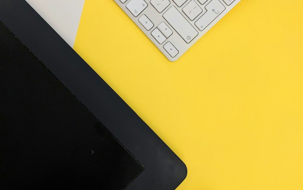gray Apple wireless keyboard beside black tablet computer and stylus pen